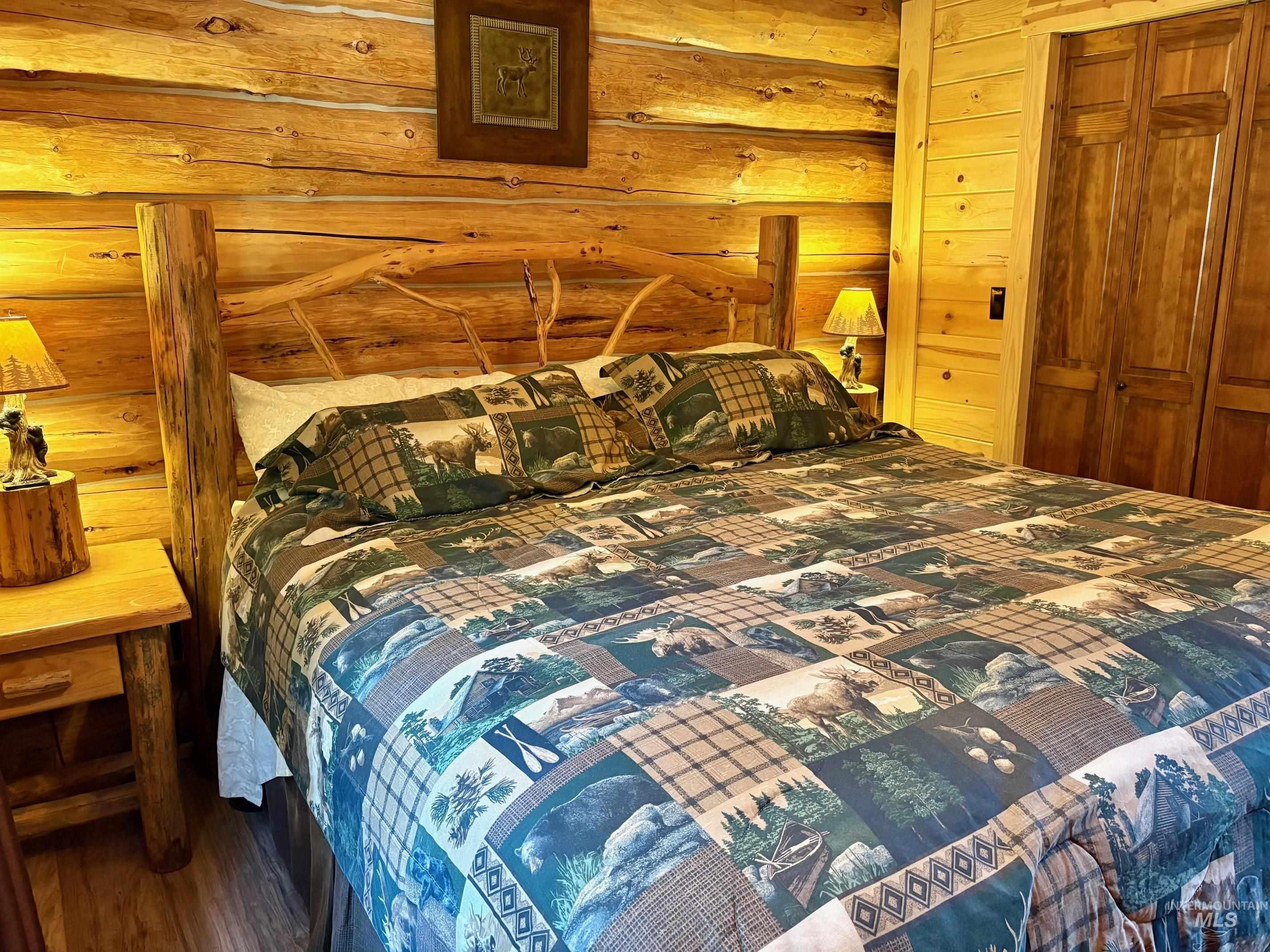 Bedroom featuring log walls and a closet