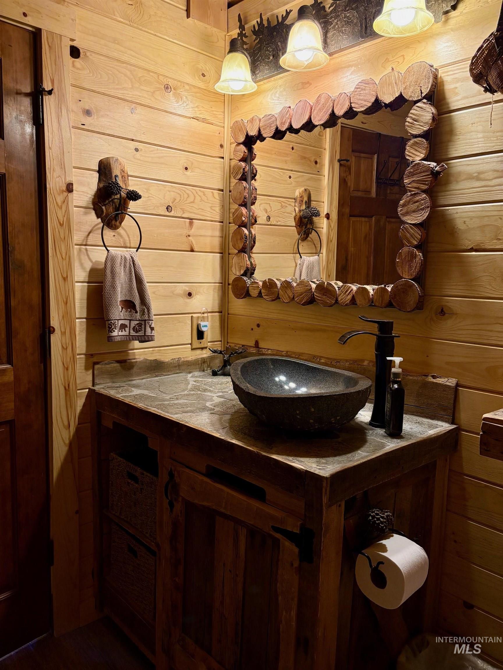 Bathroom featuring vanity and wood walls