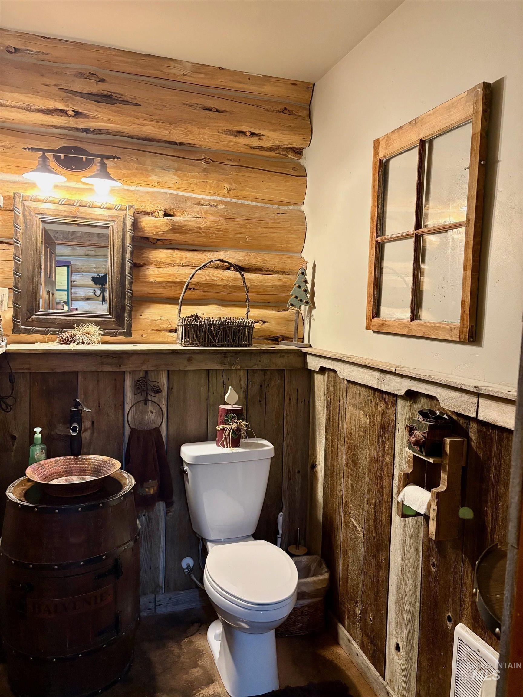 Bathroom featuring rustic walls and toilet