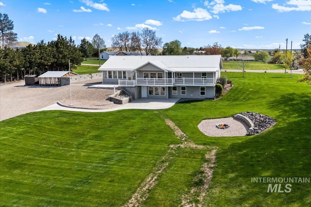 Back of house with a yard, a balcony, a patio, and stairway