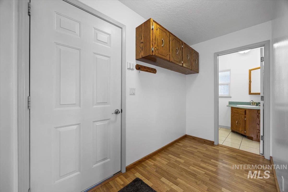 Washroom featuring a textured ceiling and light wood-style floors