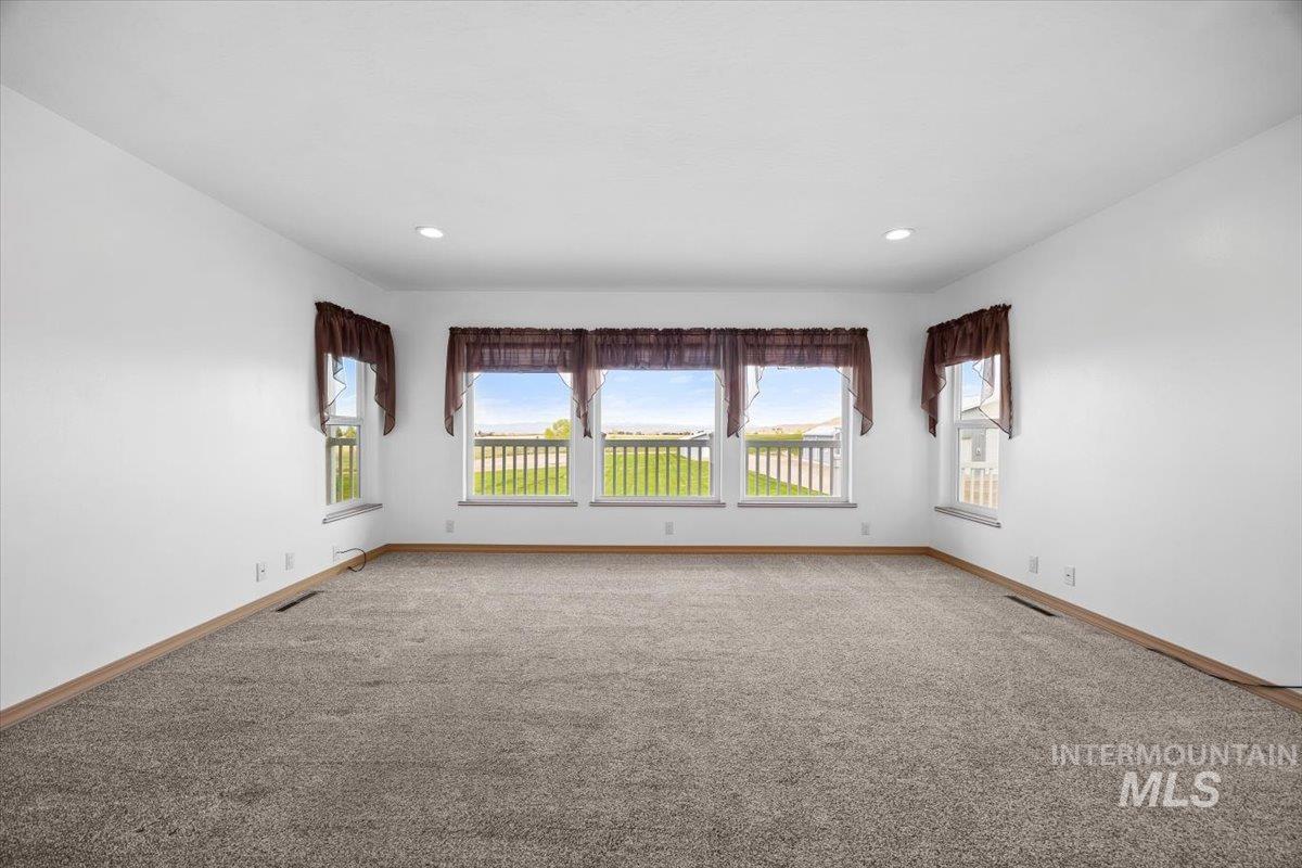 Spare room featuring baseboards and carpet