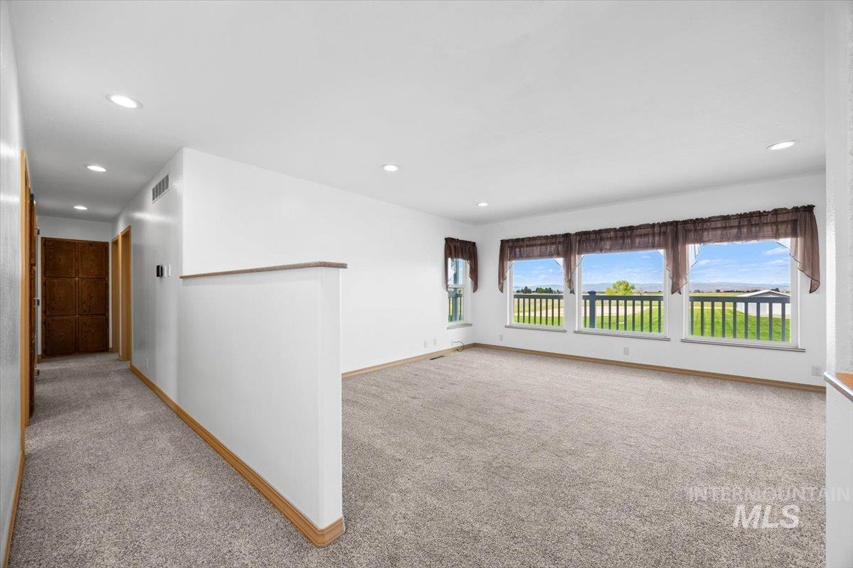 Empty room featuring light colored carpet and recessed lighting