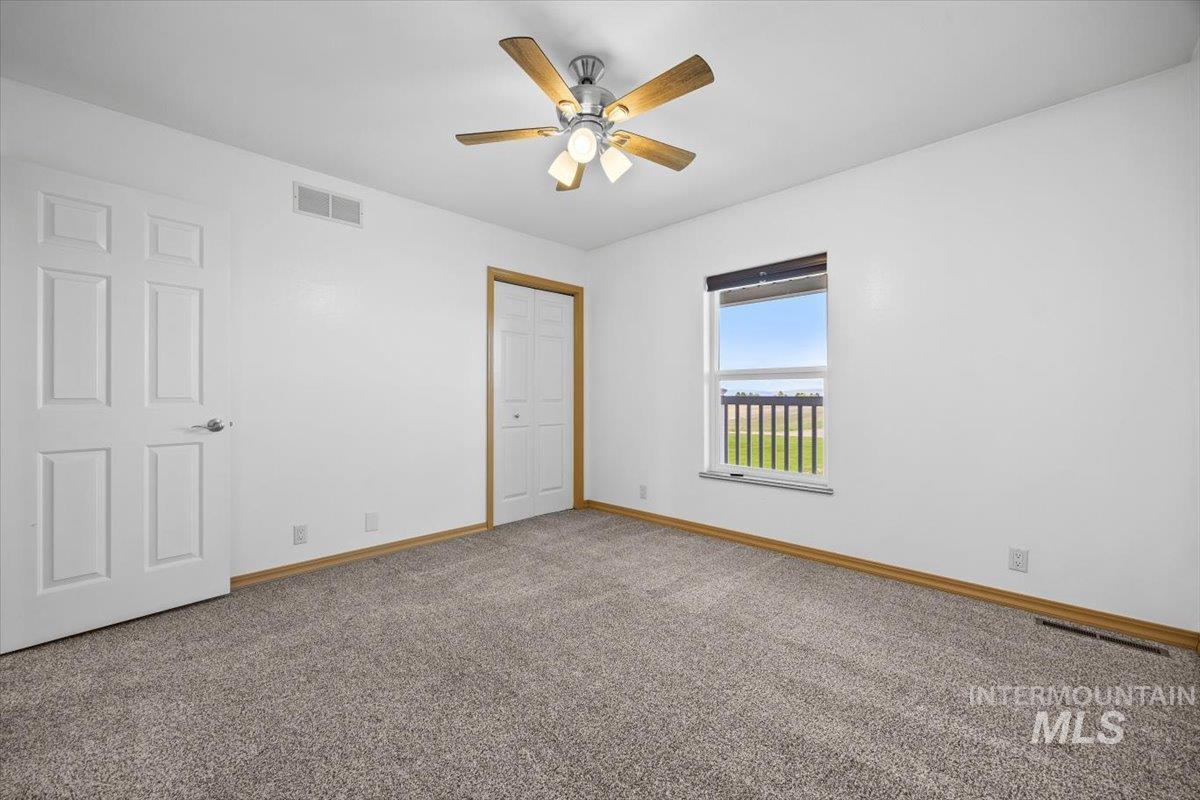 Unfurnished bedroom with carpet floors, a closet, and a ceiling fan
