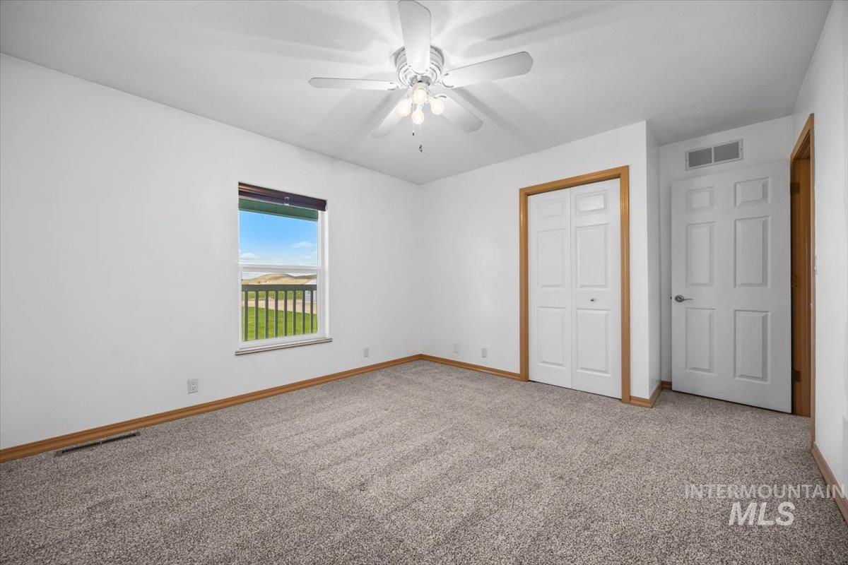Unfurnished bedroom with a closet, carpet floors, and a ceiling fan