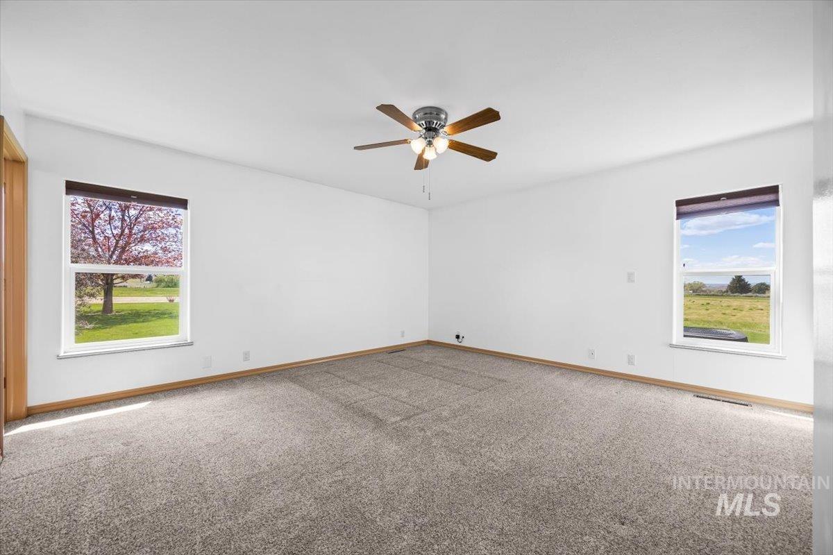 Unfurnished room featuring light colored carpet and a ceiling fan