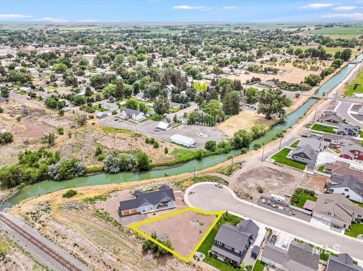 Aerial view of residential area with property boundaries highlighted and a nearby body of water