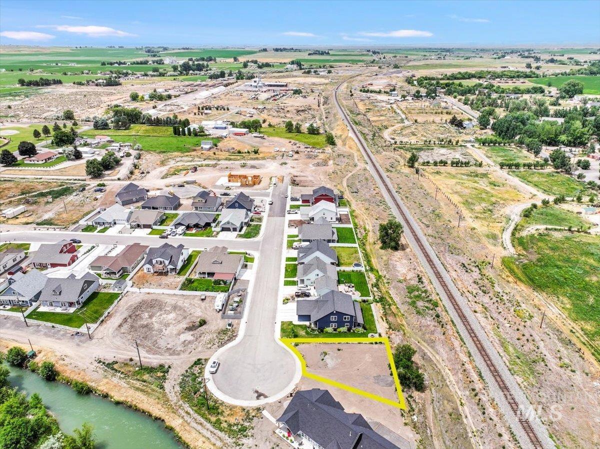 Aerial view of property and surrounding area with property parcel outlined, a large body of water, and nearby suburban area