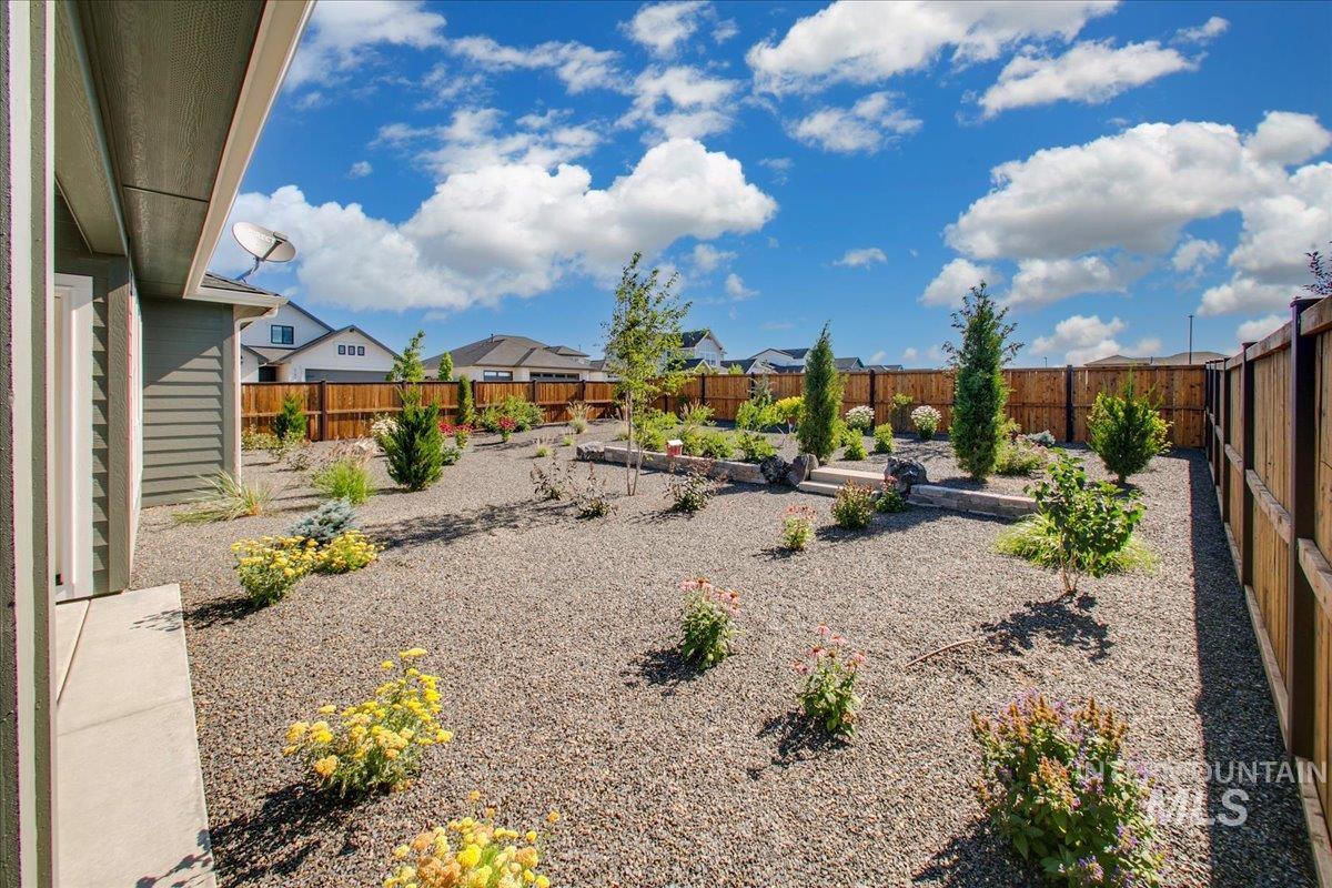 Fenced backyard featuring a vegetable garden