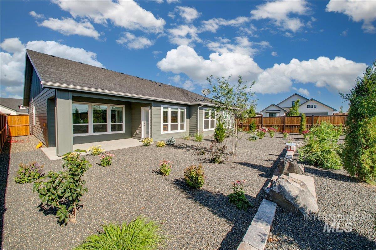Rear view of house featuring a patio, a fenced backyard, and roof with shingles