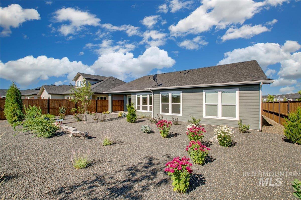 Back of property featuring a fenced backyard, a shingled roof, and a patio