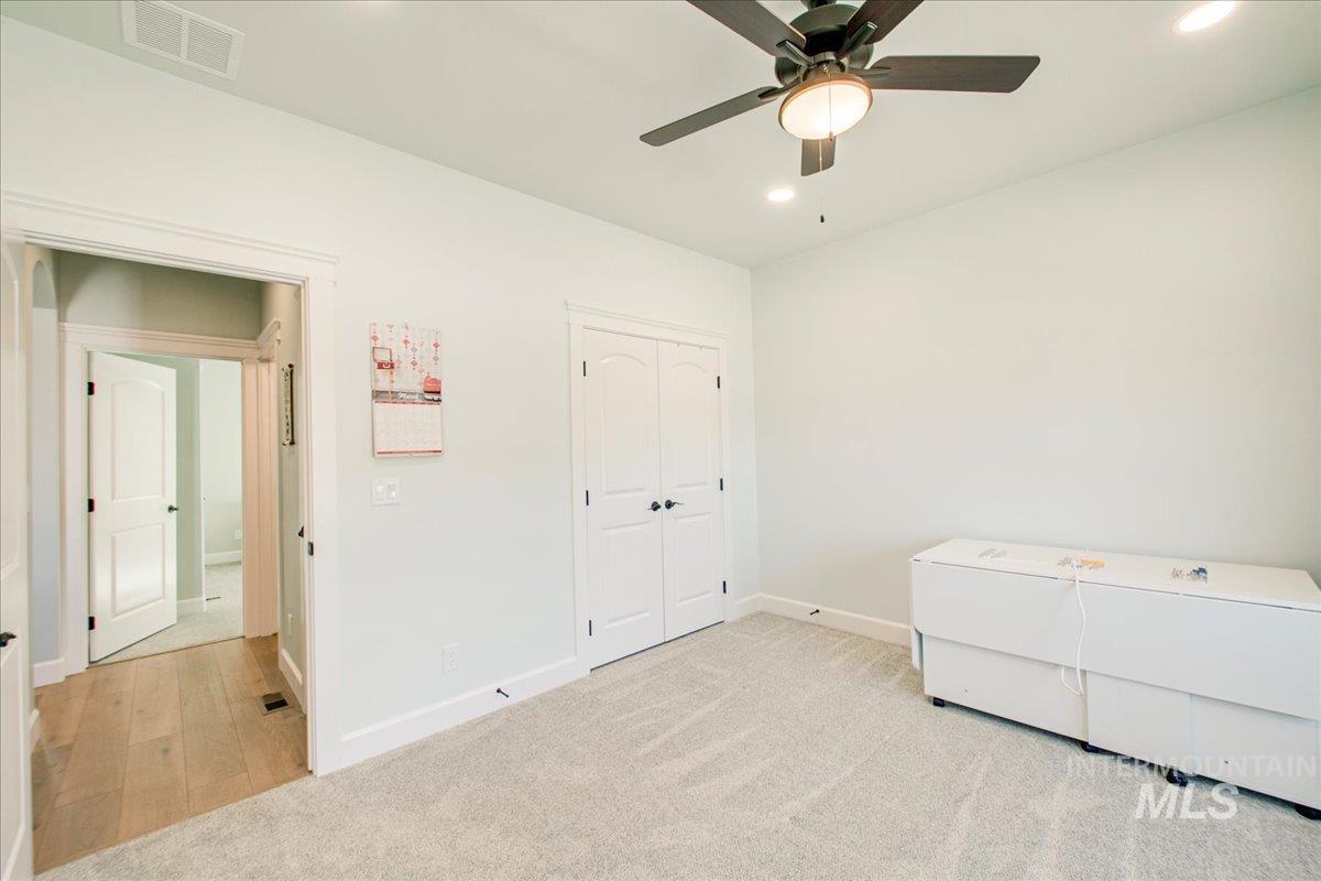 Unfurnished bedroom with carpet floors, ceiling fan, a closet, and recessed lighting