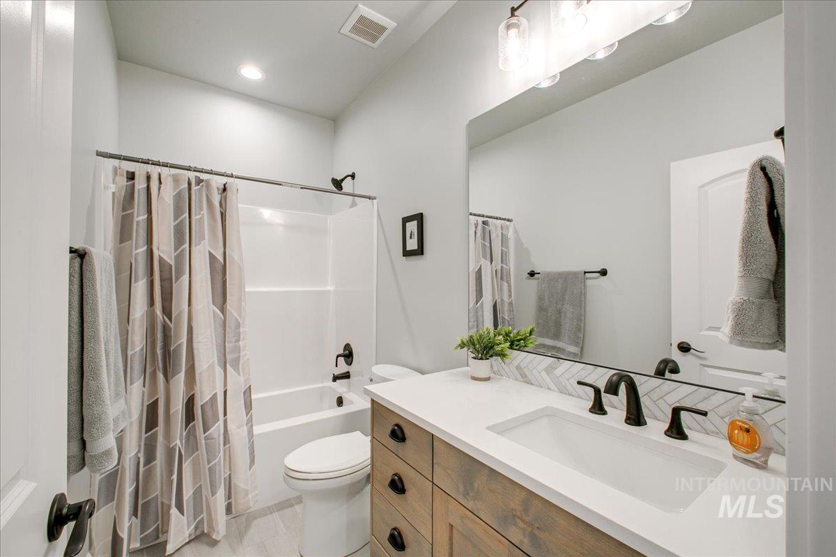 Full bath featuring shower / bath combo, vanity, and recessed lighting