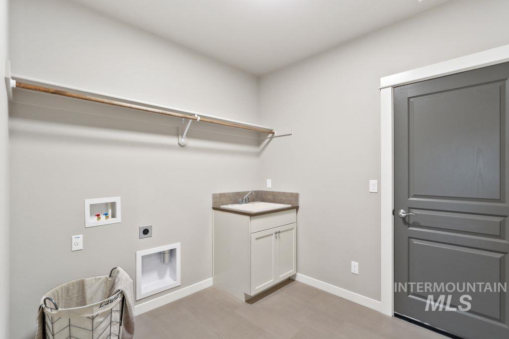 Laundry area with hookup for an electric dryer, hookup for a washing machine, and cabinet space