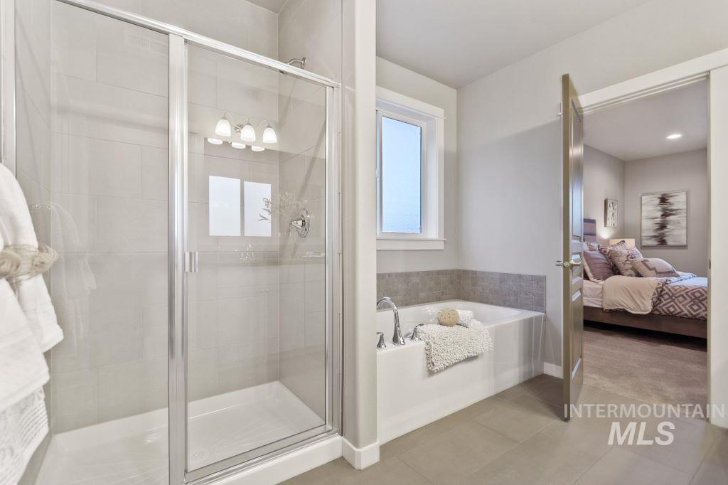 Full bathroom with ensuite bathroom, a garden tub, a stall shower, light tile patterned floors, and light carpet