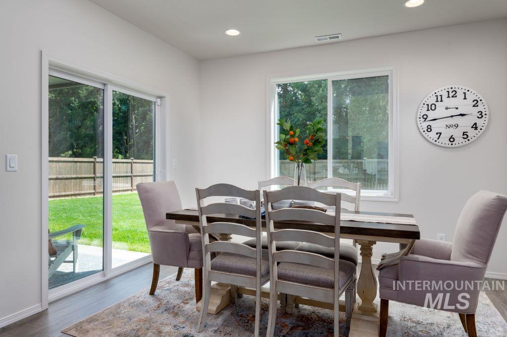 Dining space with healthy amount of natural light, wood finished floors, and recessed lighting