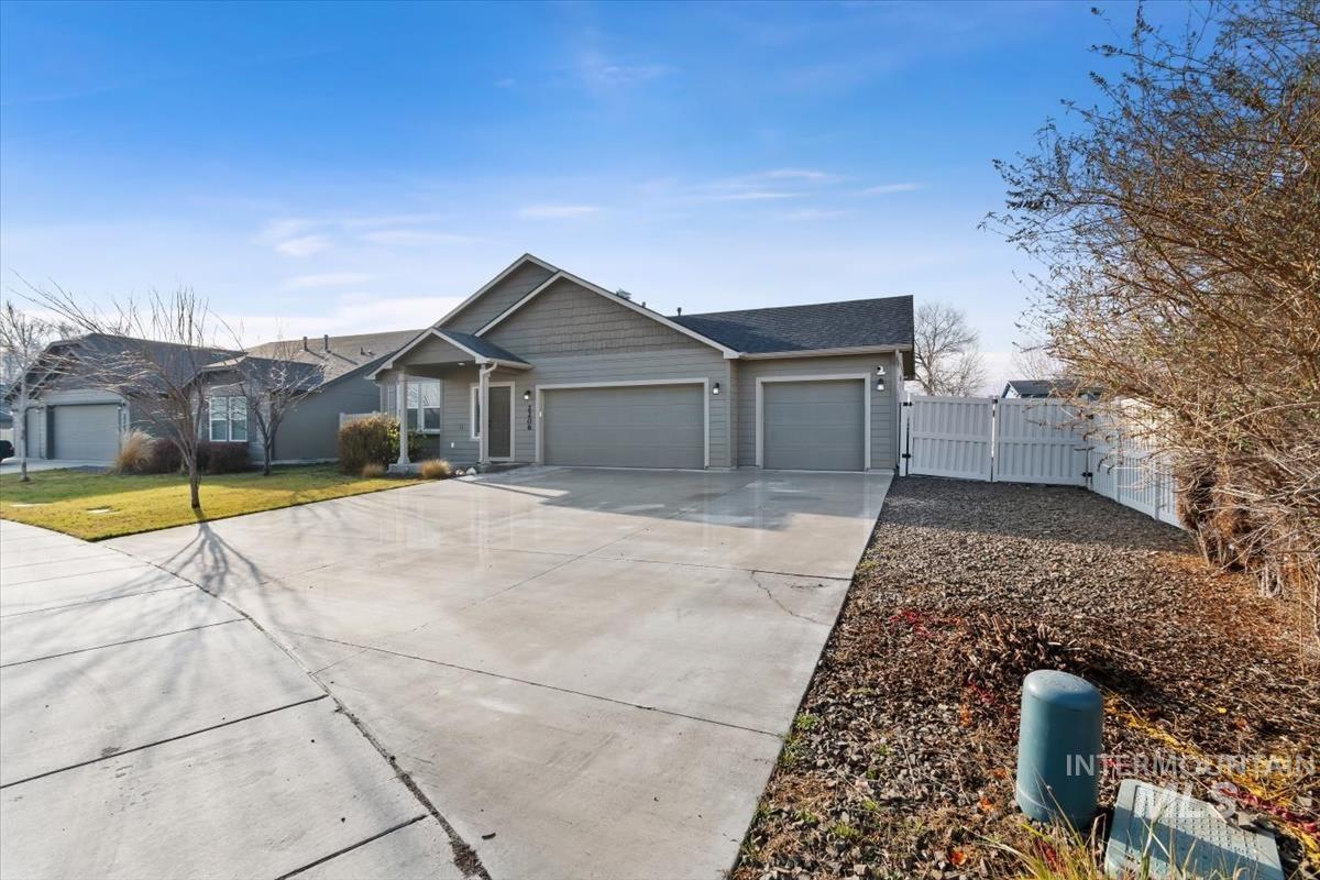 View of front of house with a gate, a garage, and concrete driveway