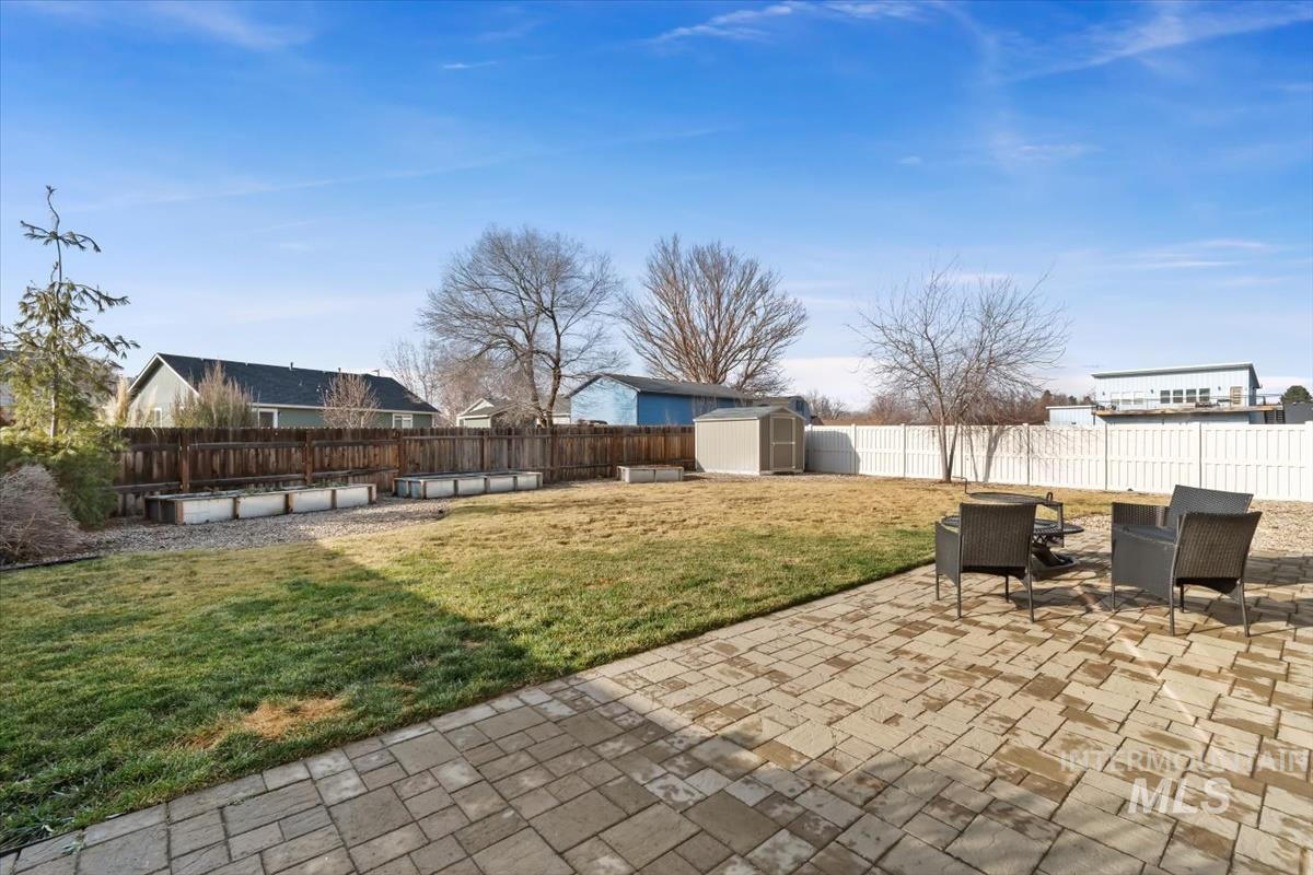Fenced backyard with a patio area and a shed