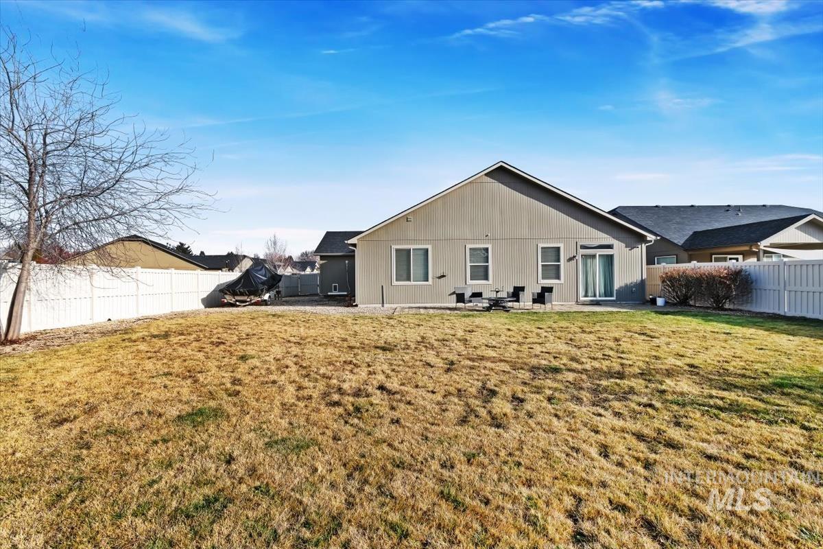 Rear view of house featuring a fenced backyard and a patio
