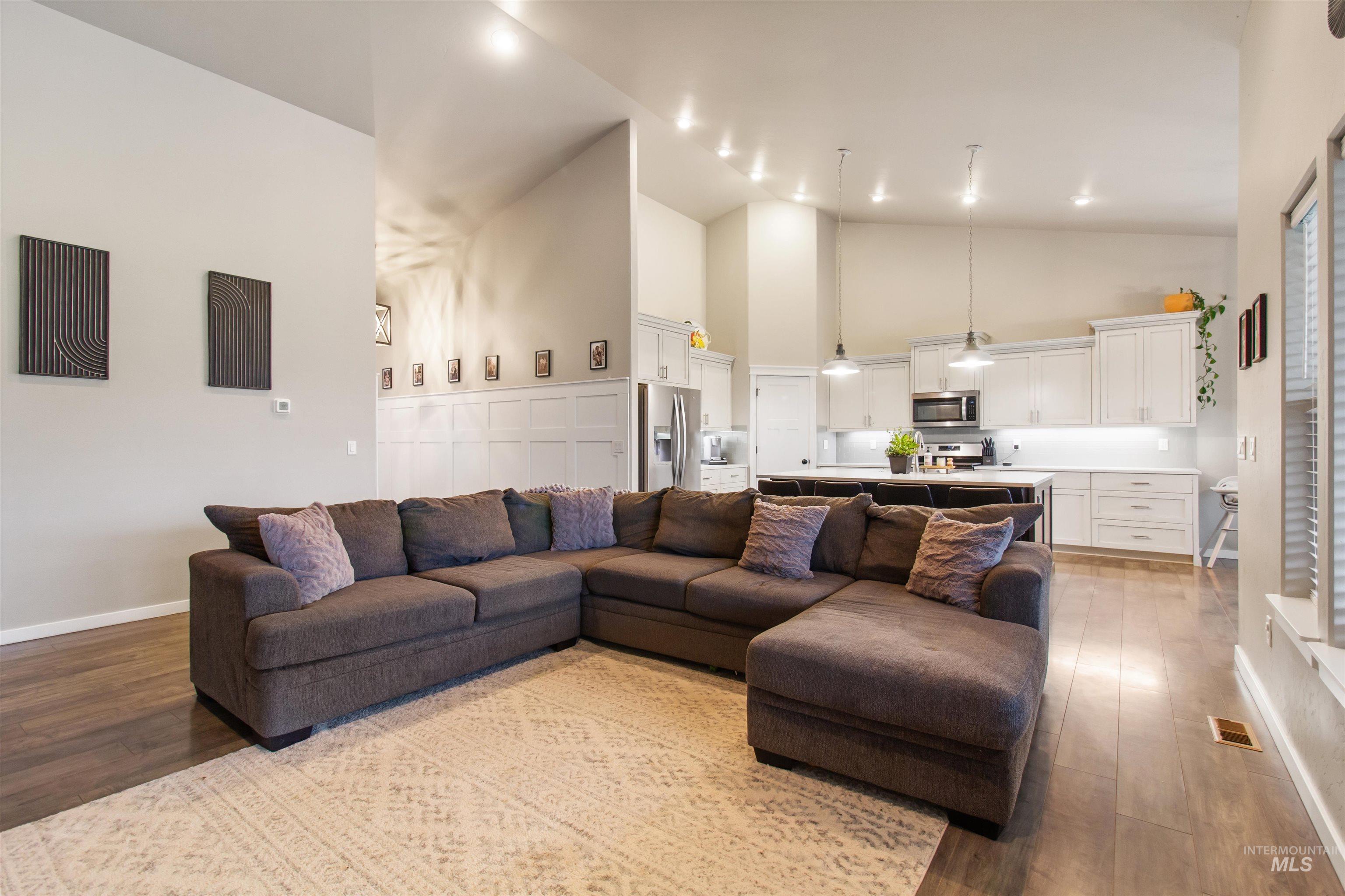 Living area featuring high vaulted ceiling and light wood-style flooring