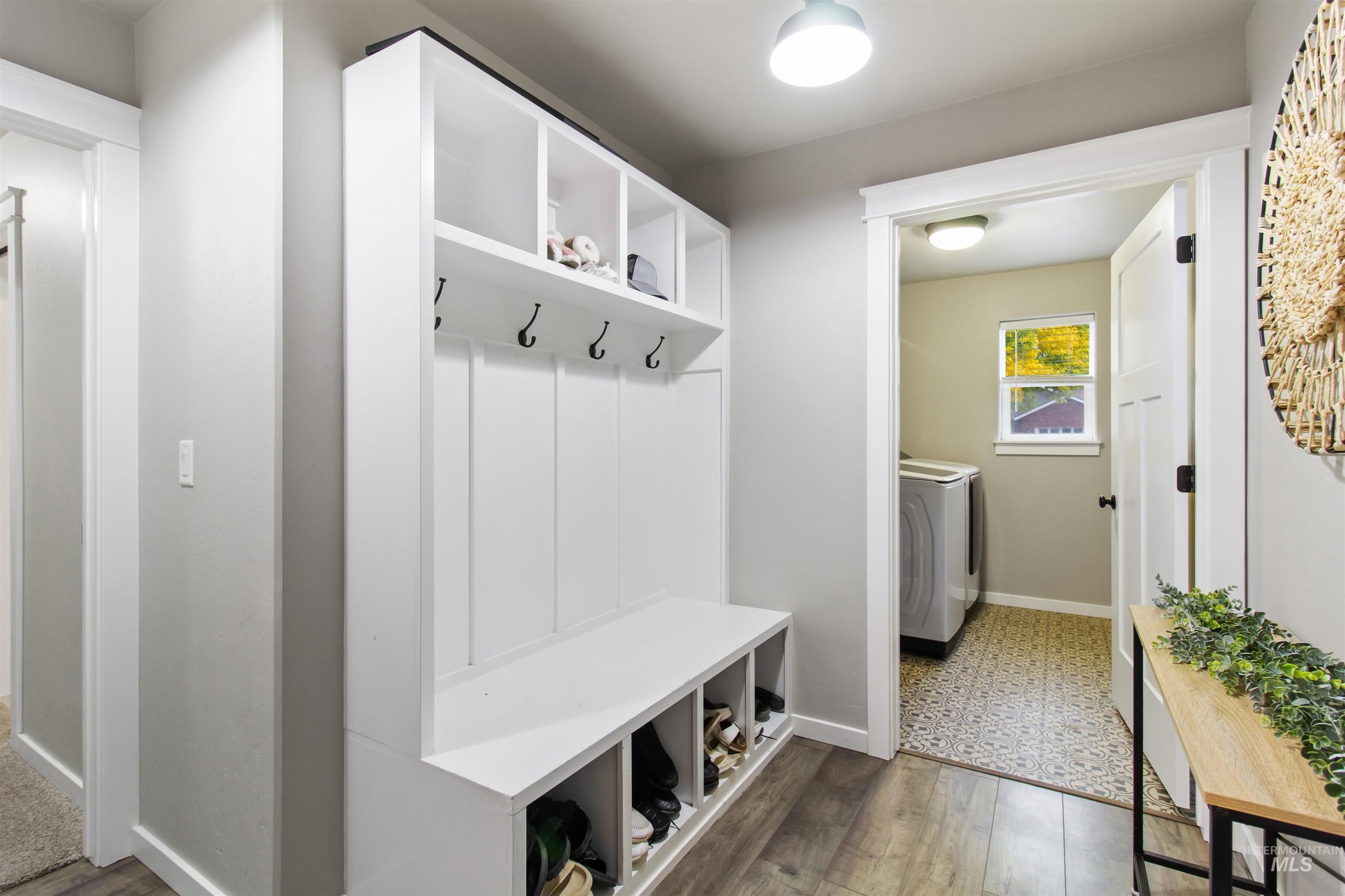 Mudroom with dark wood-type flooring and washing machine and dryer