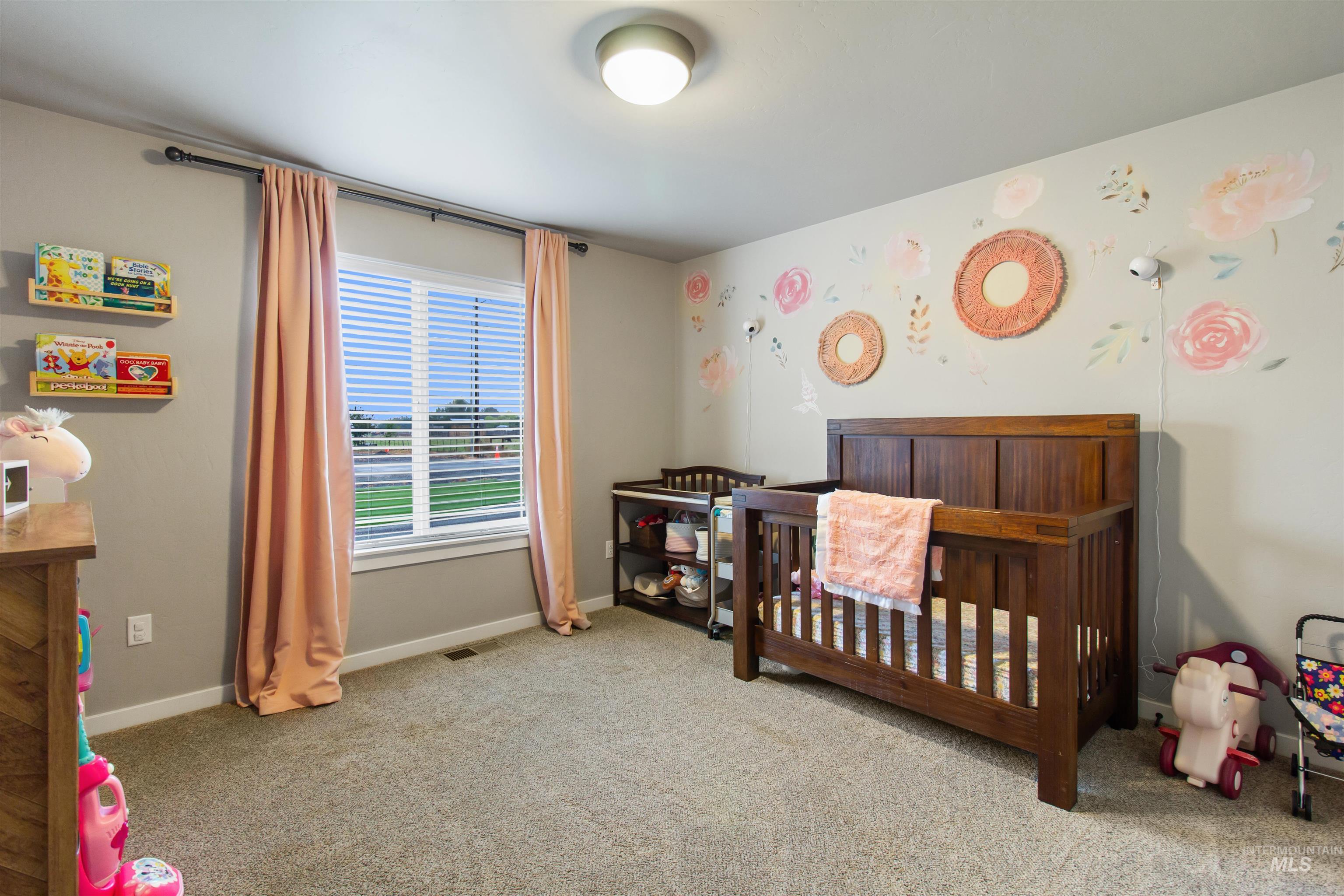 Bedroom featuring a crib and light carpet