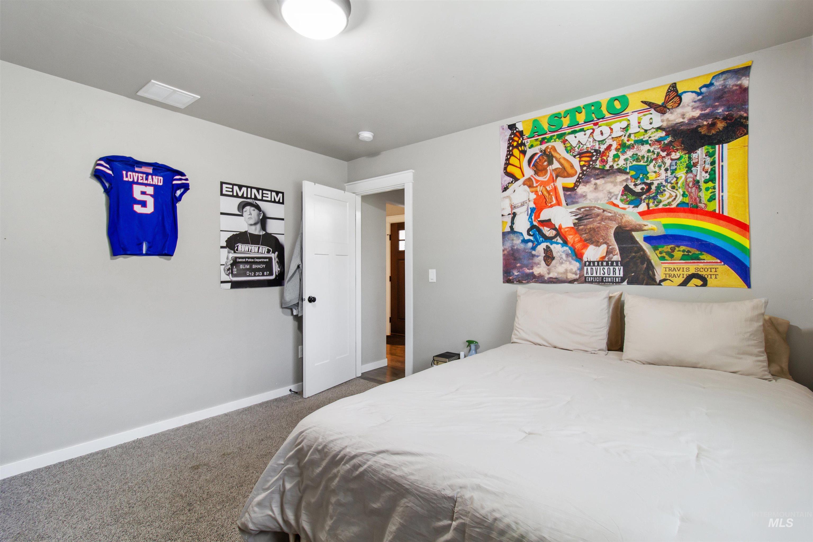Bedroom with dark carpet and baseboards
