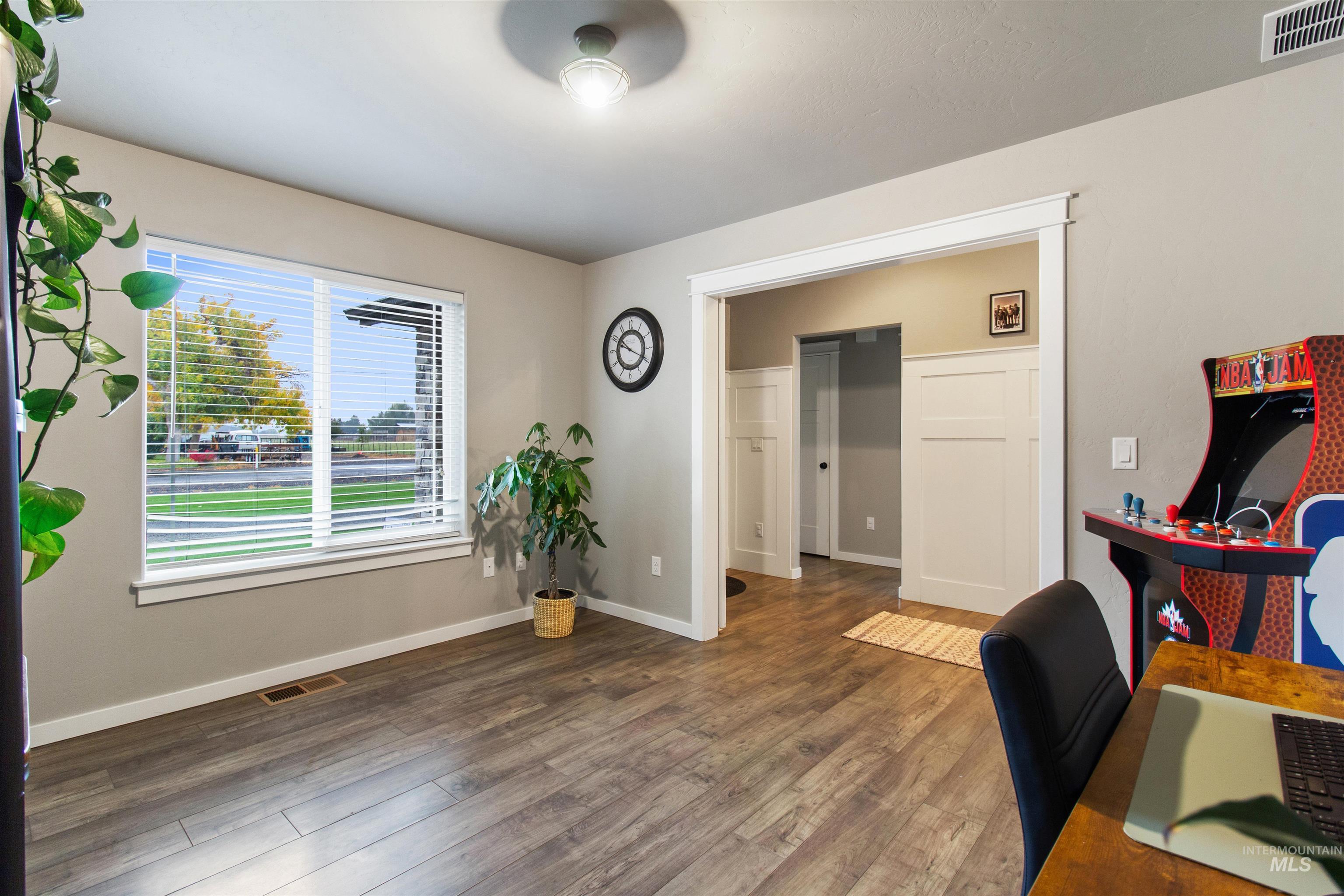 Home office with dark wood-style flooring and baseboards