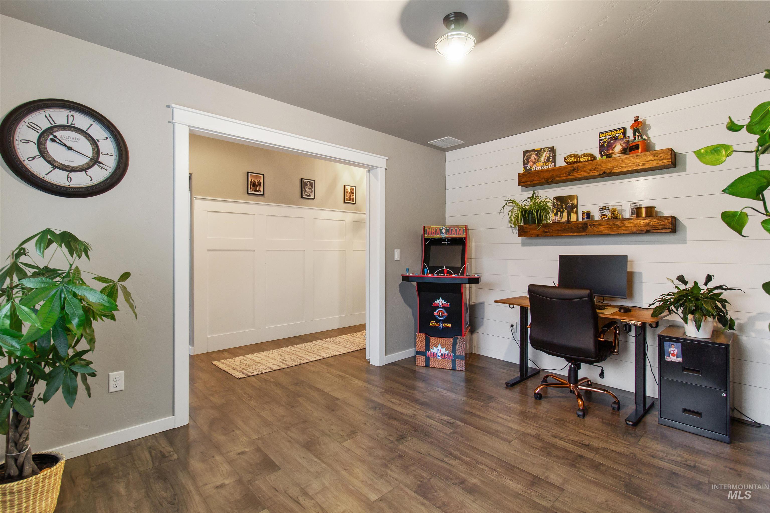 Home office featuring dark wood-style floors and baseboards