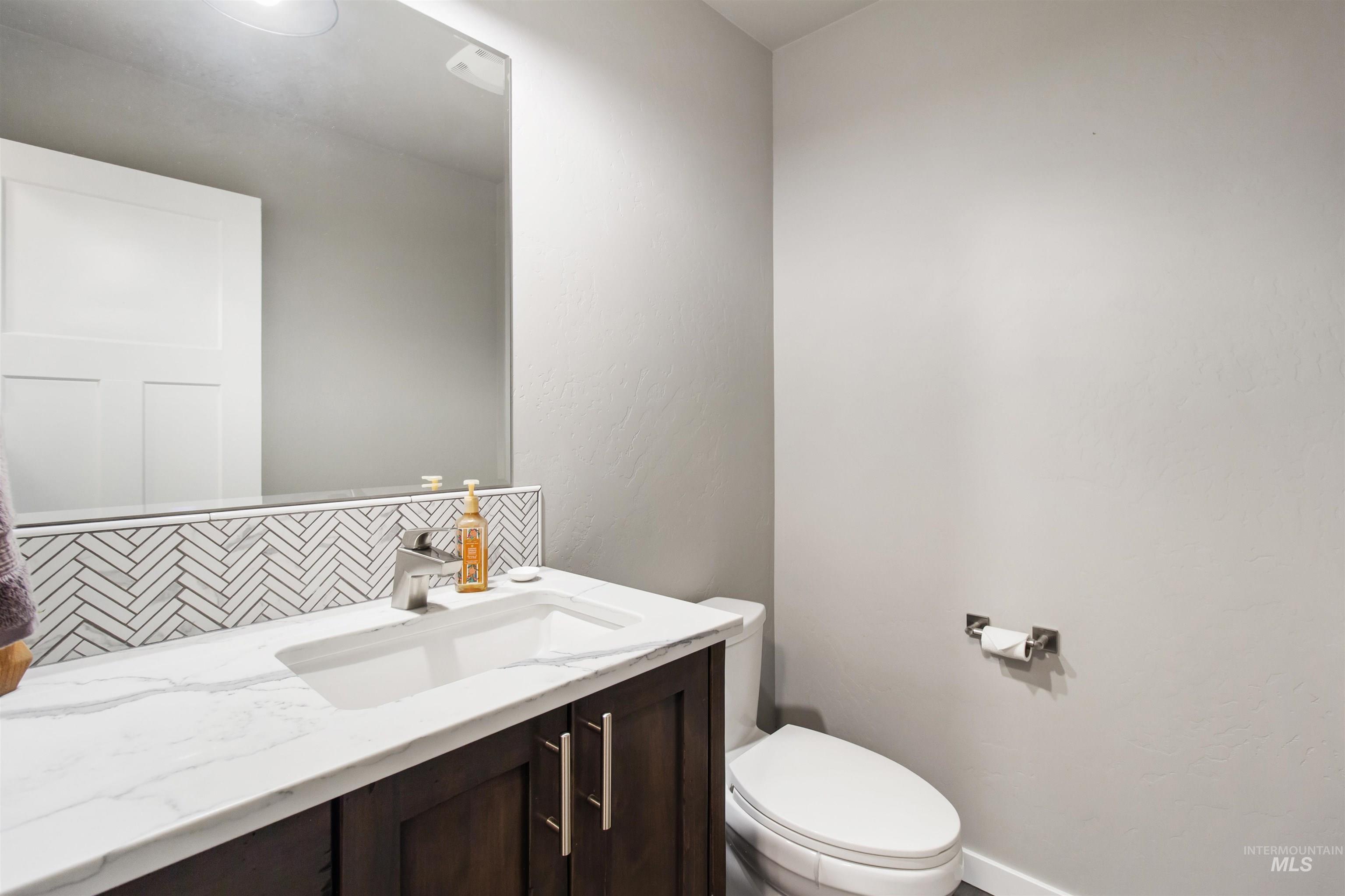 Bathroom featuring vanity and decorative backsplash
