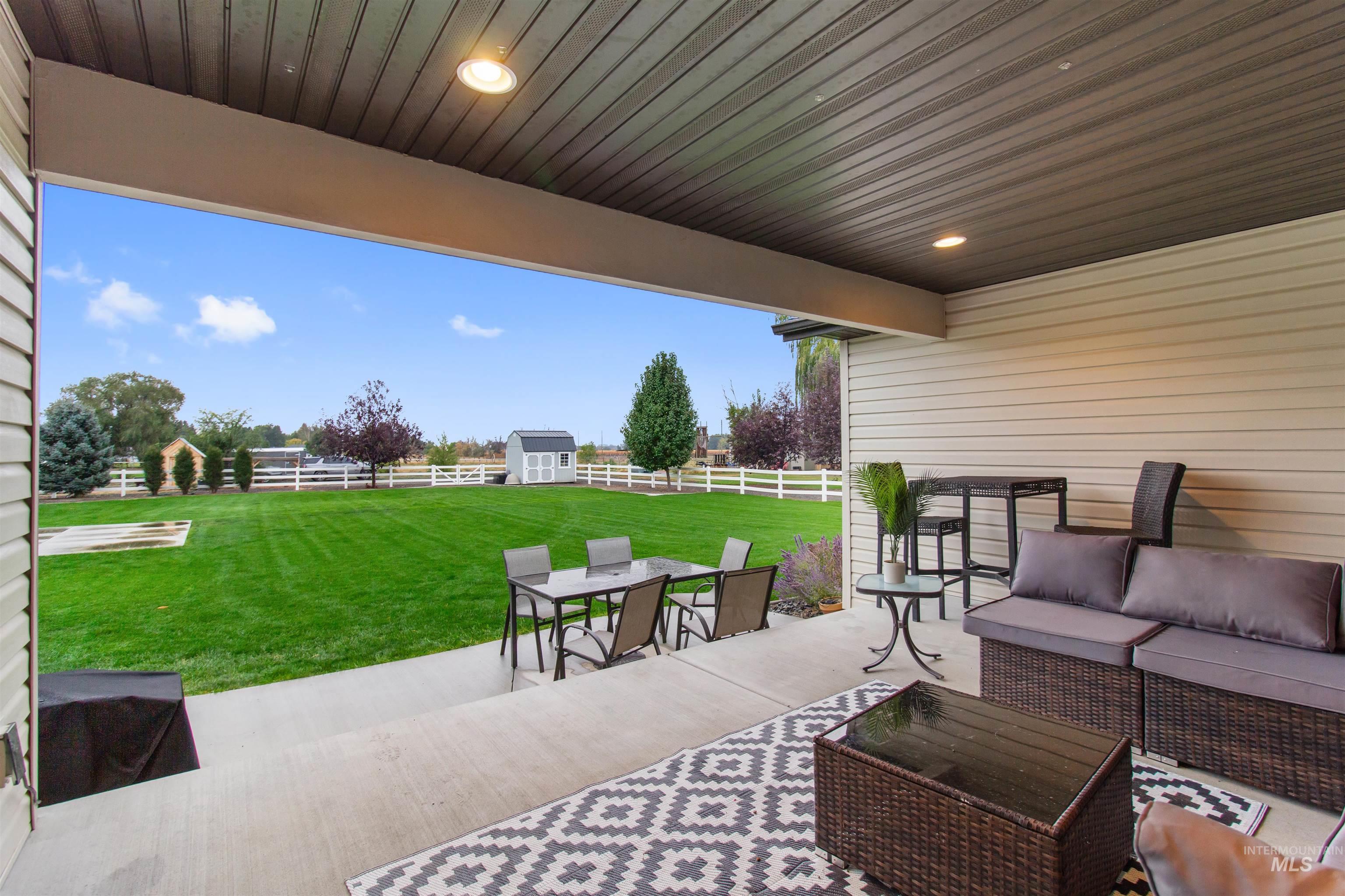 Fenced backyard featuring a patio area, outdoor dining space, outdoor lounge area, and a storage shed