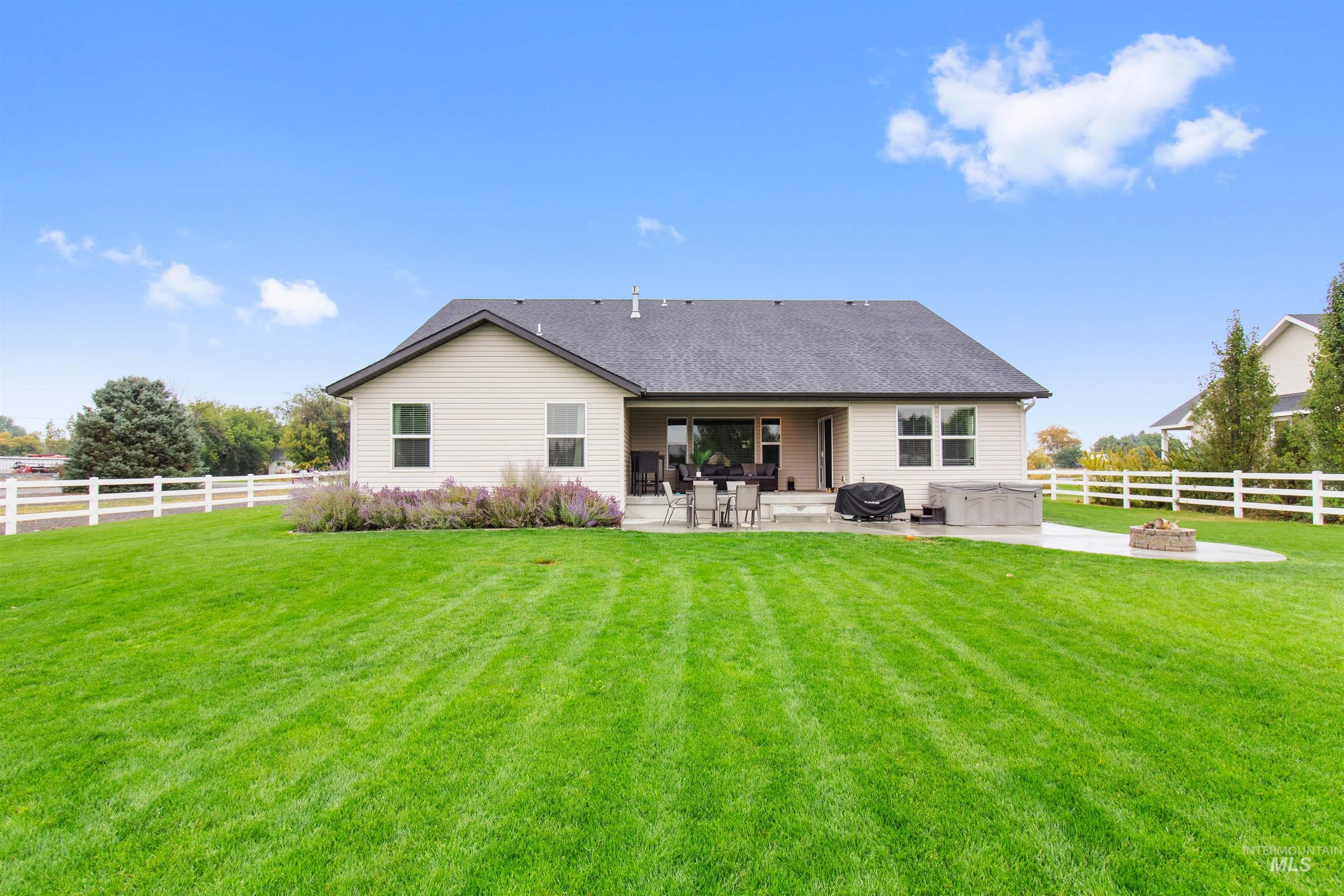 Rear view of house featuring an outdoor fire pit, a fenced backyard, a patio, and roof with shingles