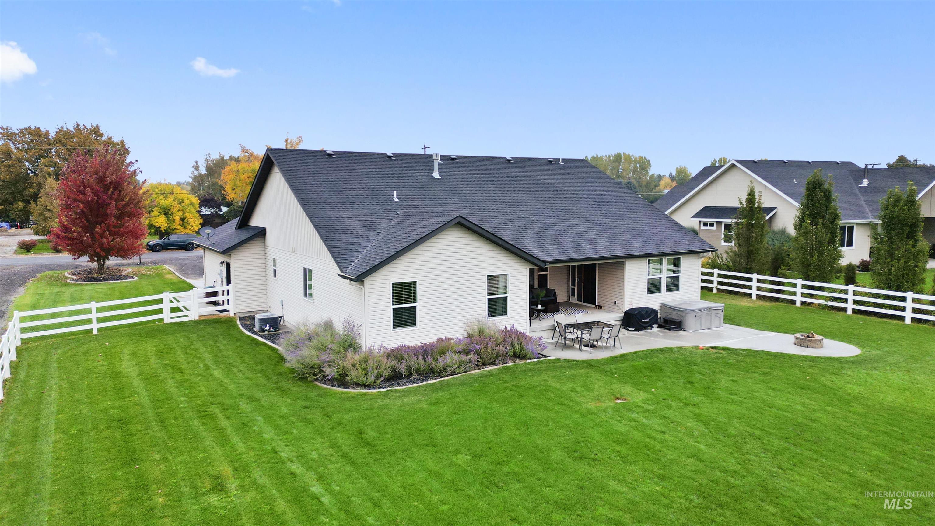 Back of house with a fenced backyard, a patio, a shingled roof, and an outdoor fire pit