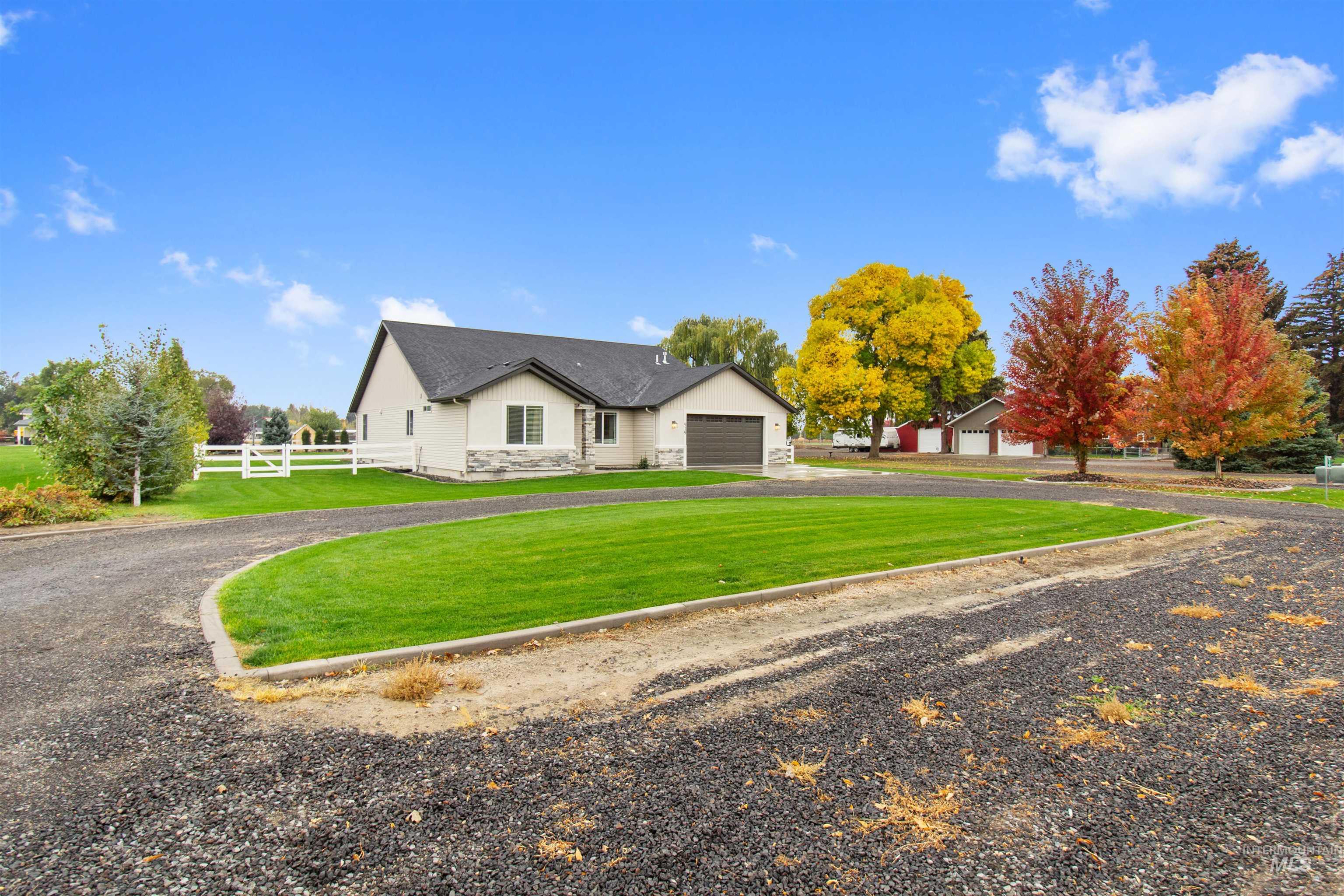 View of front of home with stone siding, driveway, and stucco siding