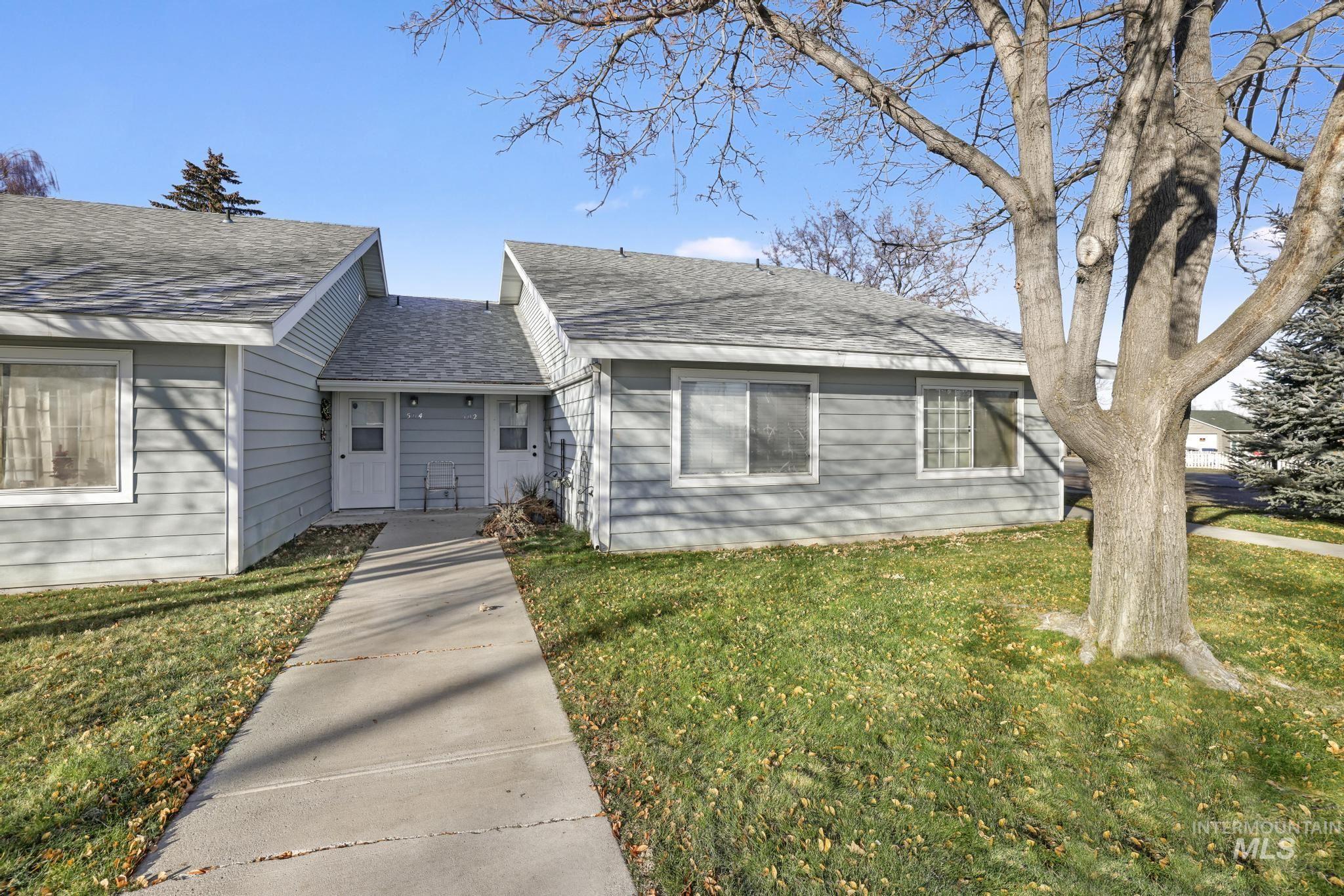 View of front of property featuring a front lawn and roof with shingles