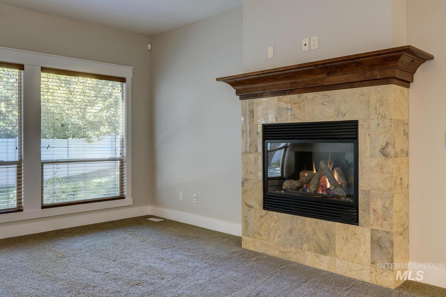 Detailed view of a tile fireplace and carpet floors