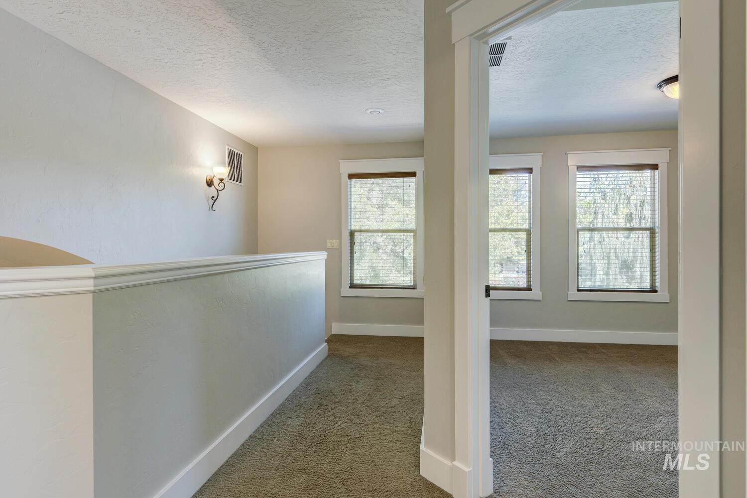 Hall with carpet and a textured ceiling