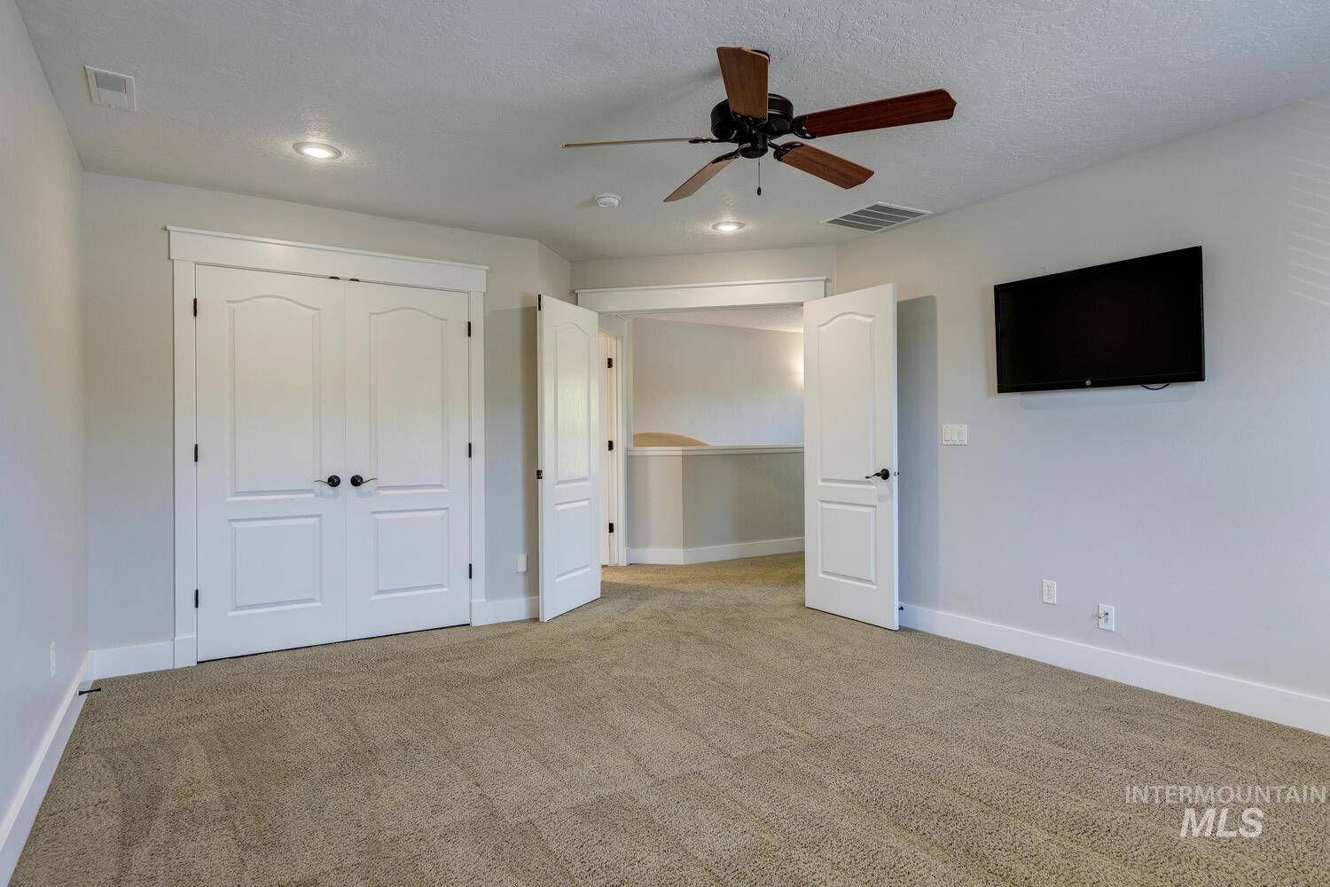 Unfurnished bedroom featuring carpet floors, ceiling fan, a closet, recessed lighting, and a textured ceiling
