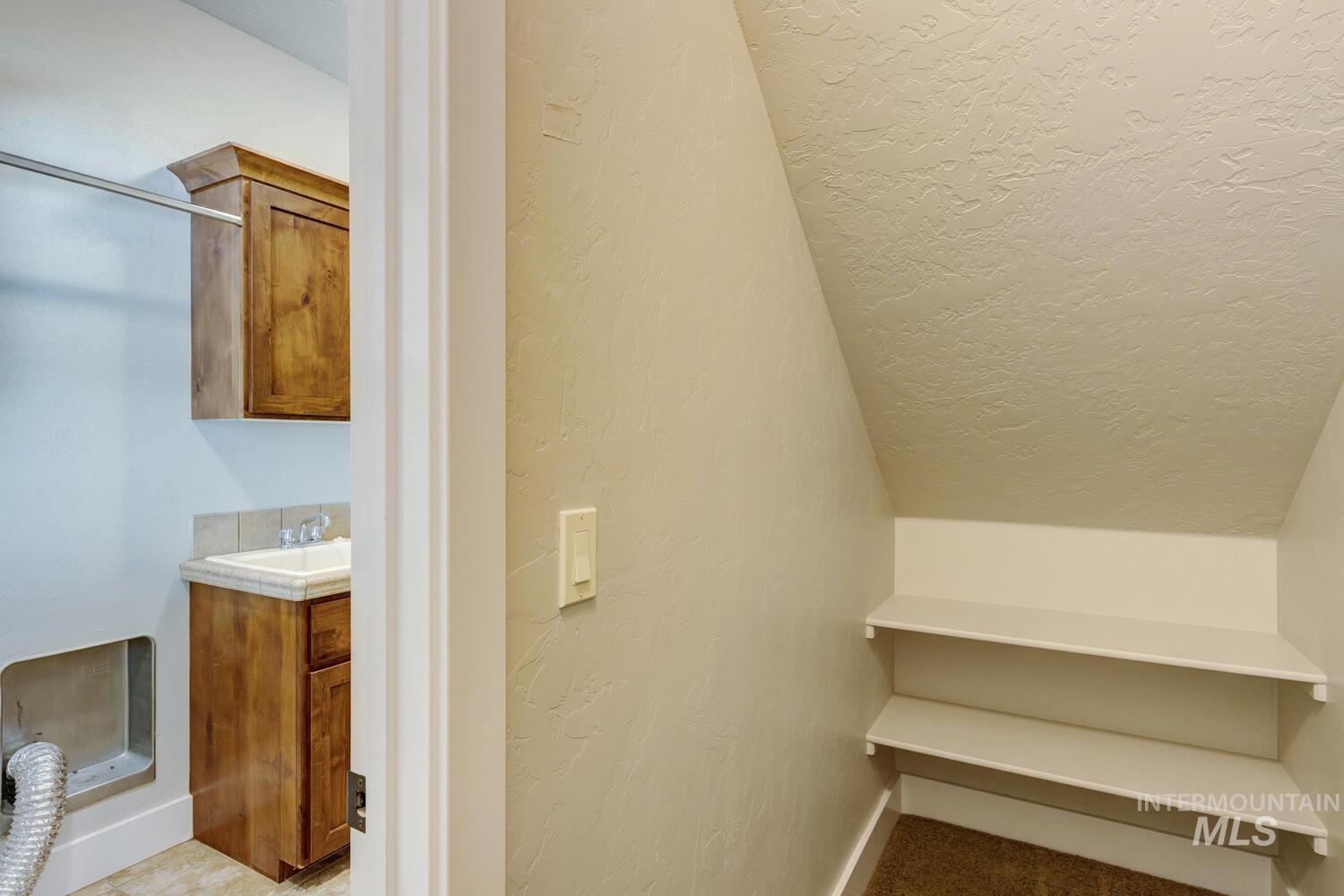 Staircase featuring a textured wall and a textured ceiling