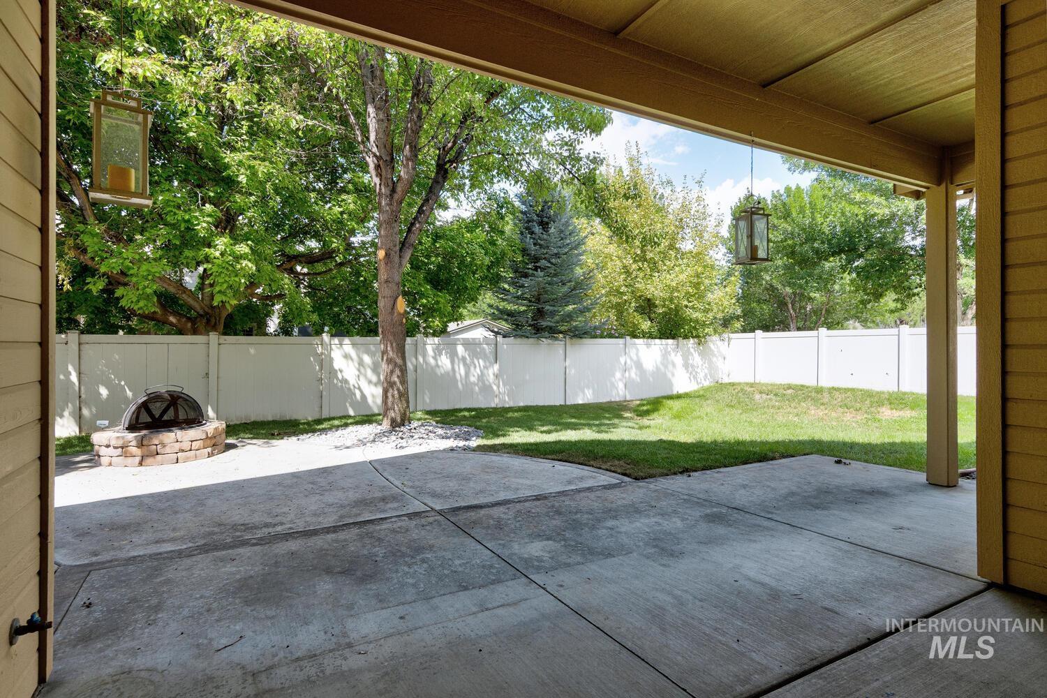 Fenced backyard with a patio and a fire pit