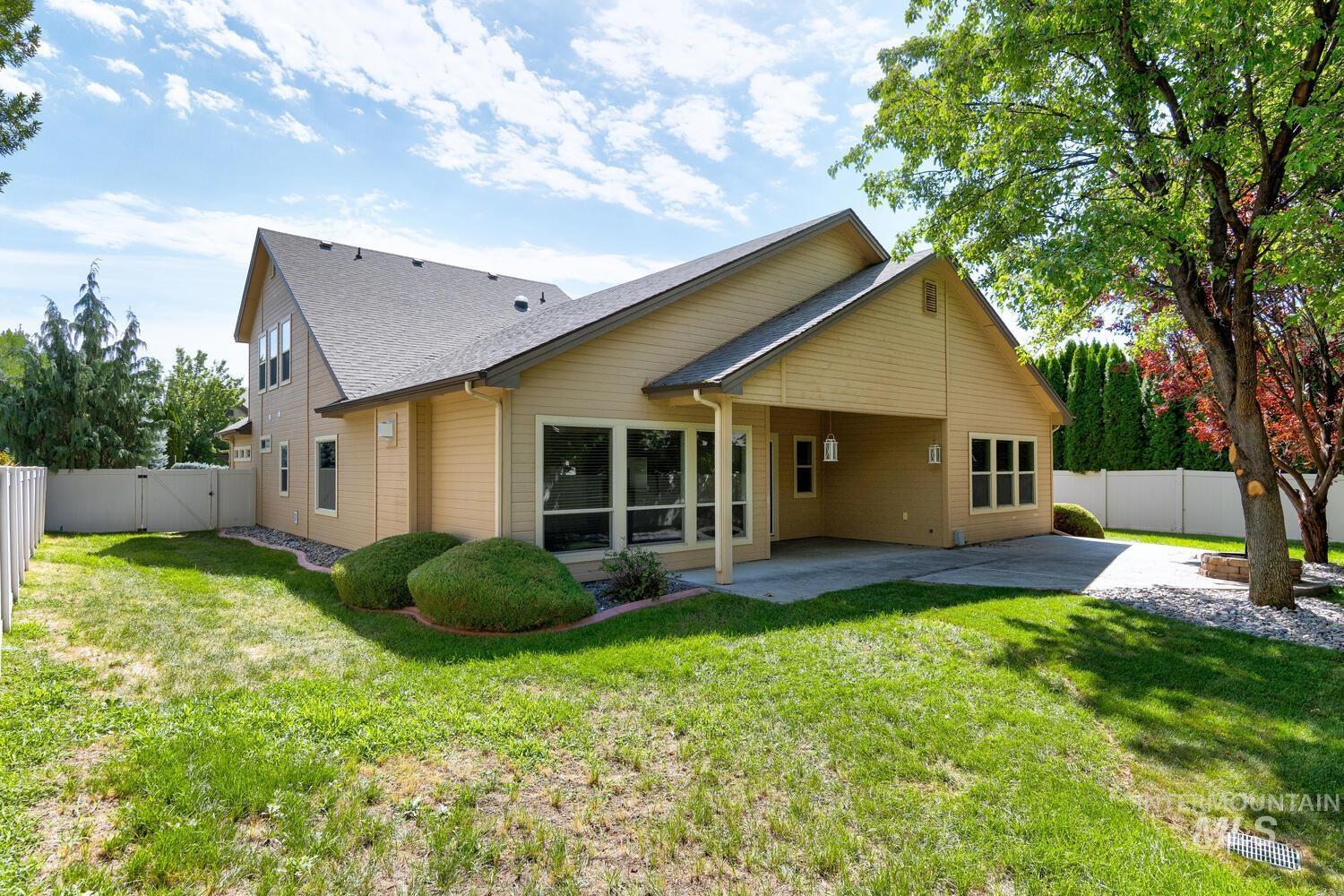 Rear view of house featuring a fenced backyard, a patio, a gate, and a shingled roof