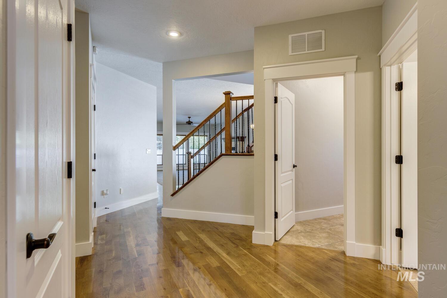 Corridor with wood finished floors, stairs, and recessed lighting