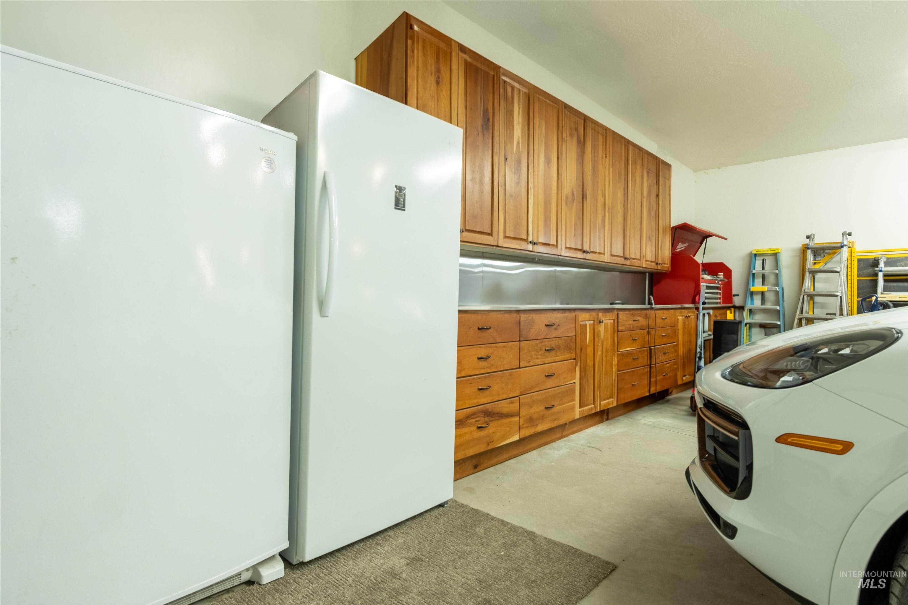 Garage featuring freestanding refrigerator and refrigerator