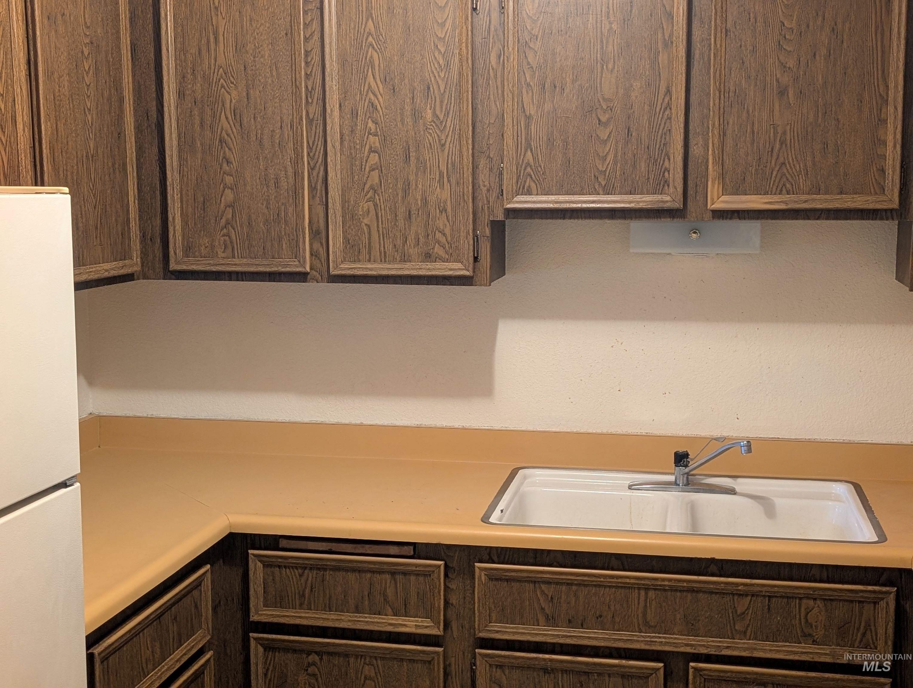 Kitchen with freestanding refrigerator and light countertops