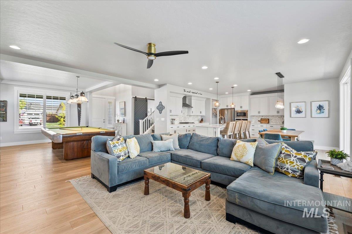 Living area with light wood-type flooring, billiards table, recessed lighting, and a ceiling fan