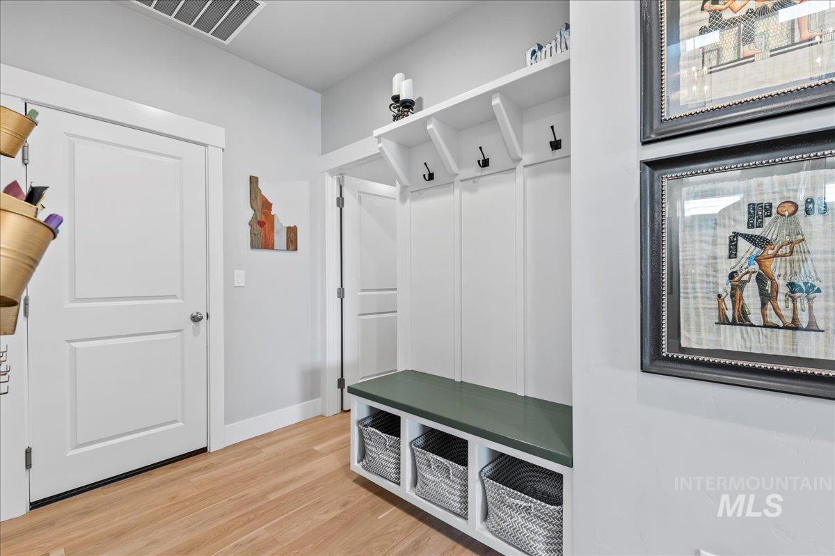 Mudroom with light wood-type flooring and baseboards