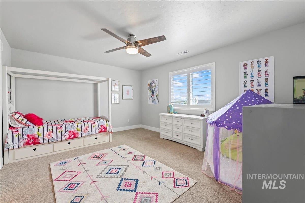 Bedroom with carpet flooring, a textured ceiling, and ceiling fan