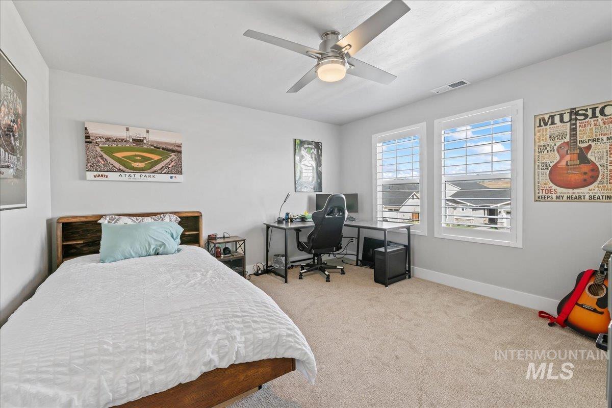 Bedroom featuring carpet flooring, ceiling fan, and an office area