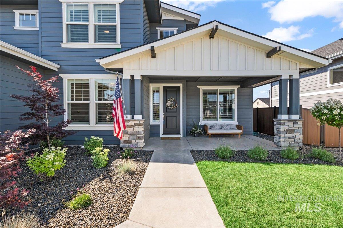 Craftsman-style home featuring board and batten siding, covered porch, and a front lawn