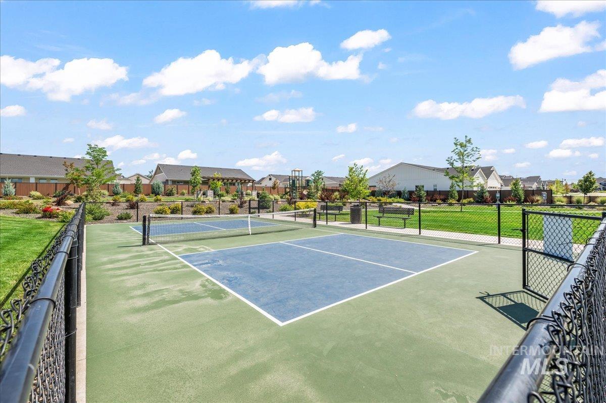 View of tennis court with a residential view